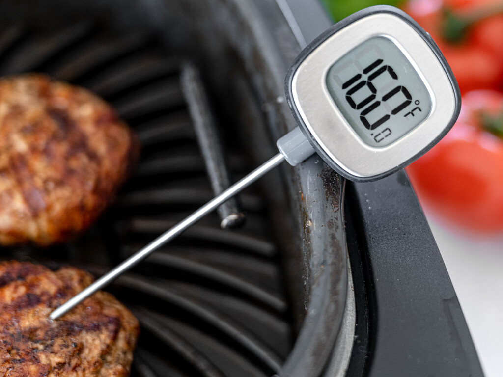 Hamburgers on grill with meat thermometer