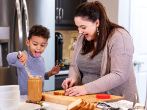 Mother and son making peanut butter sandwiches