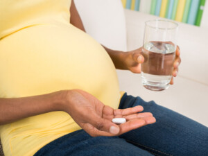 Pregnant woman with prenatal vitamin.